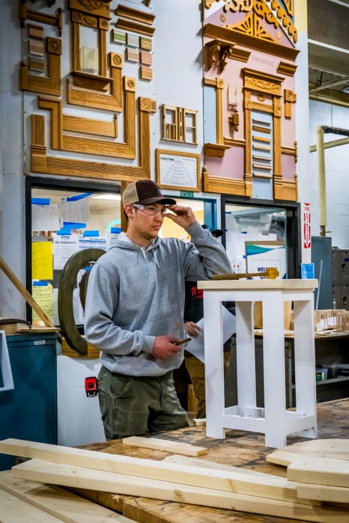 teenaged boy building furniture in a wood shop