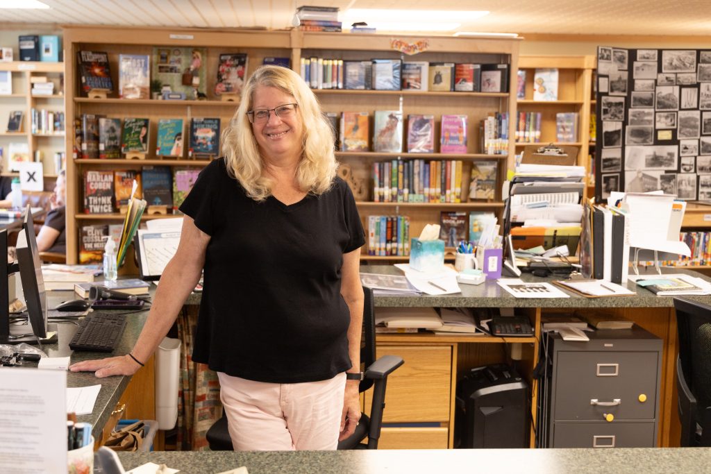 woman standing at desk in library