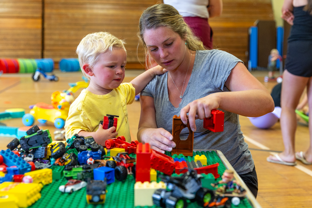 Woman and young boy play with Legos together