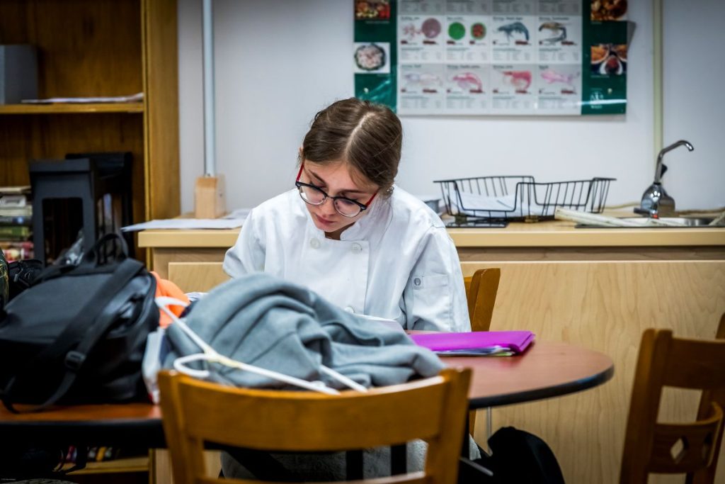Culinary student studies at table