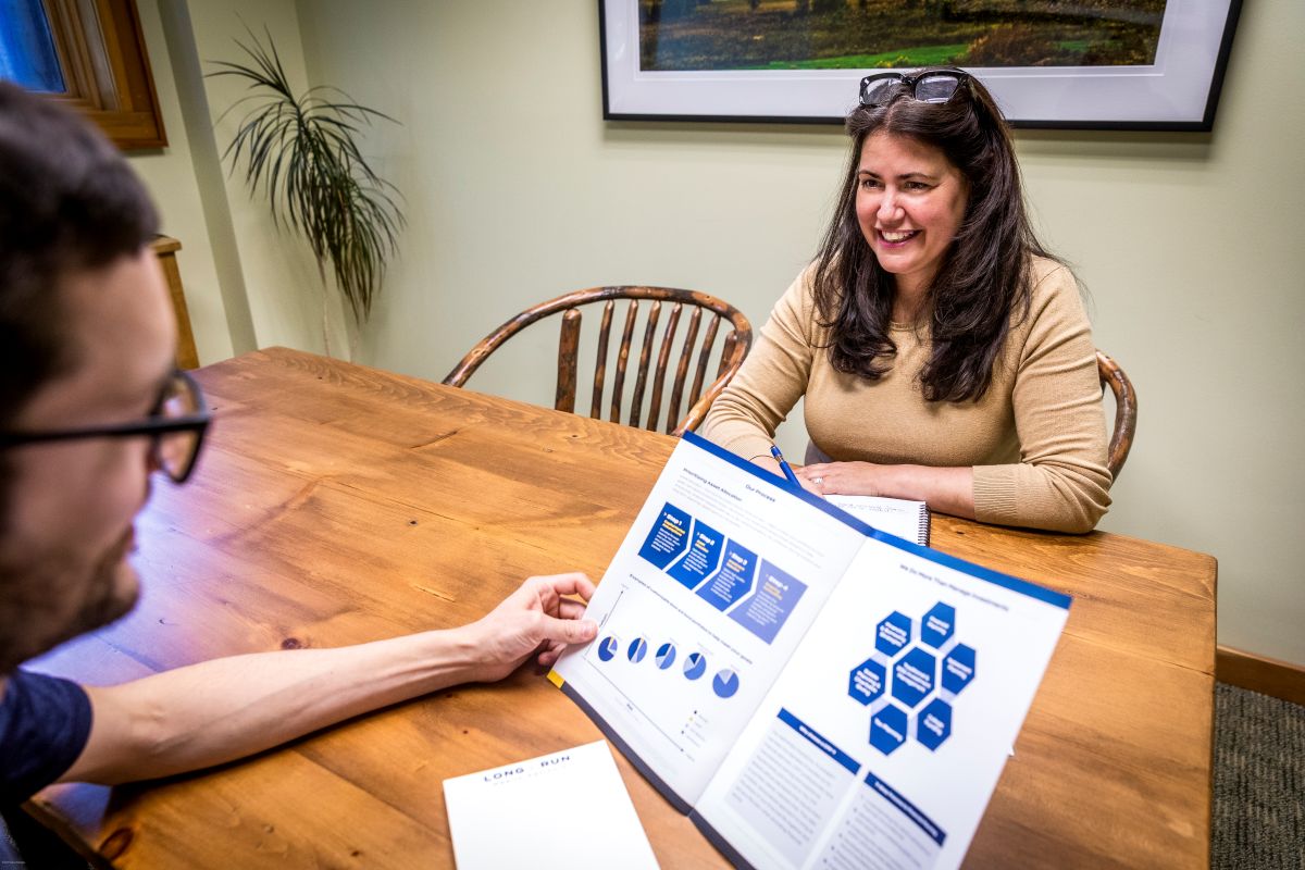 Woman shows pamphlet to man at table