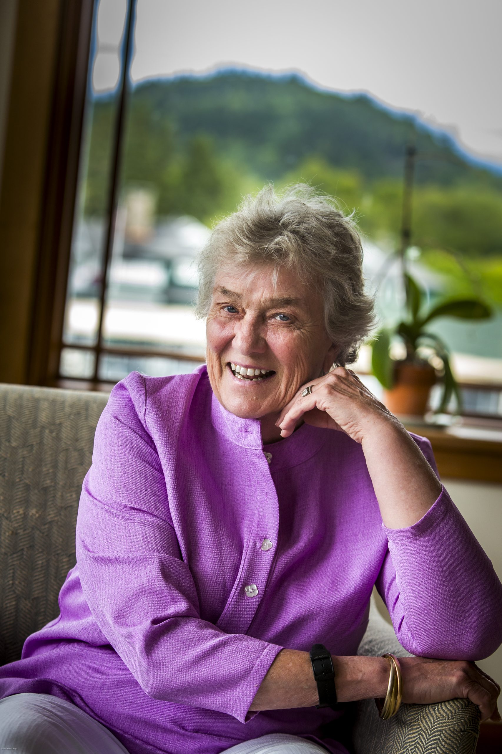Woman smiles wearing purple