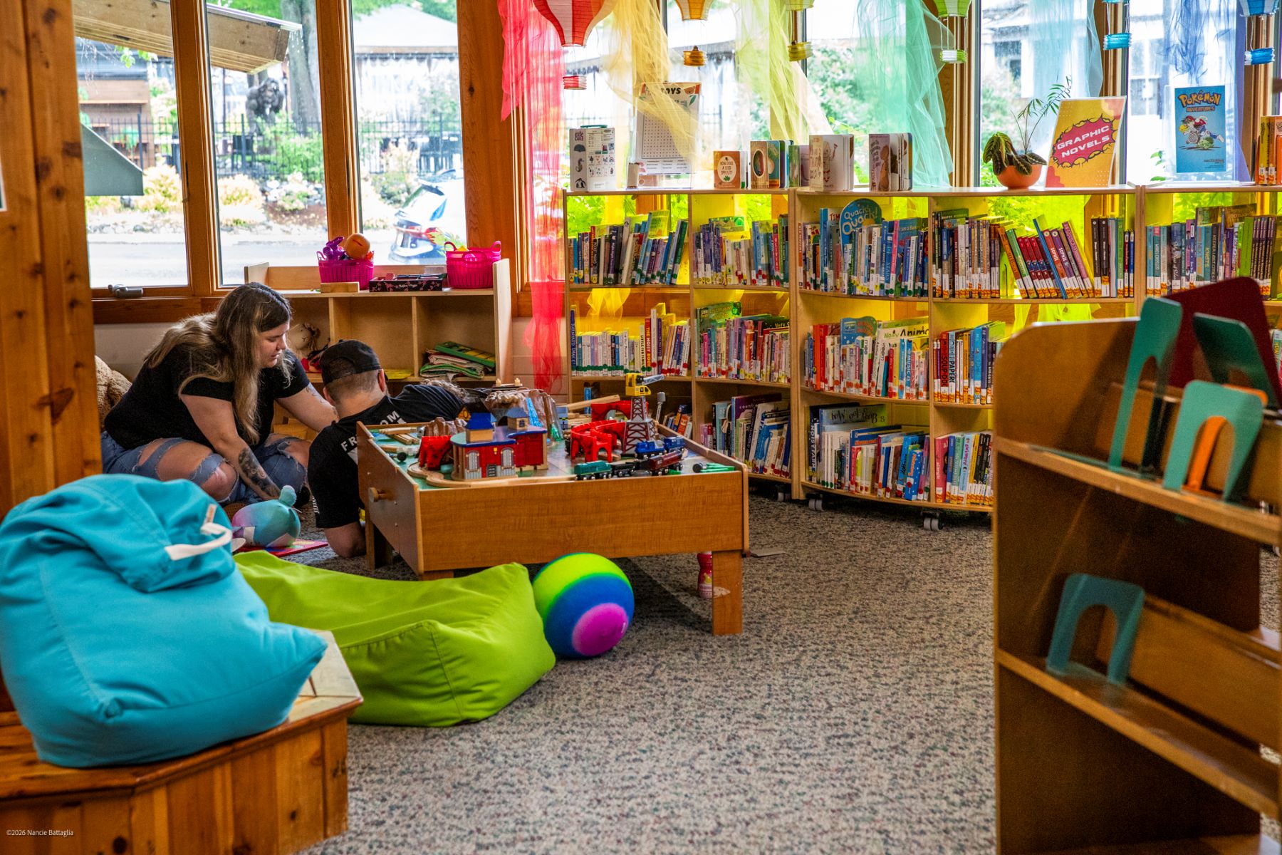 family sitting on floor in children's library