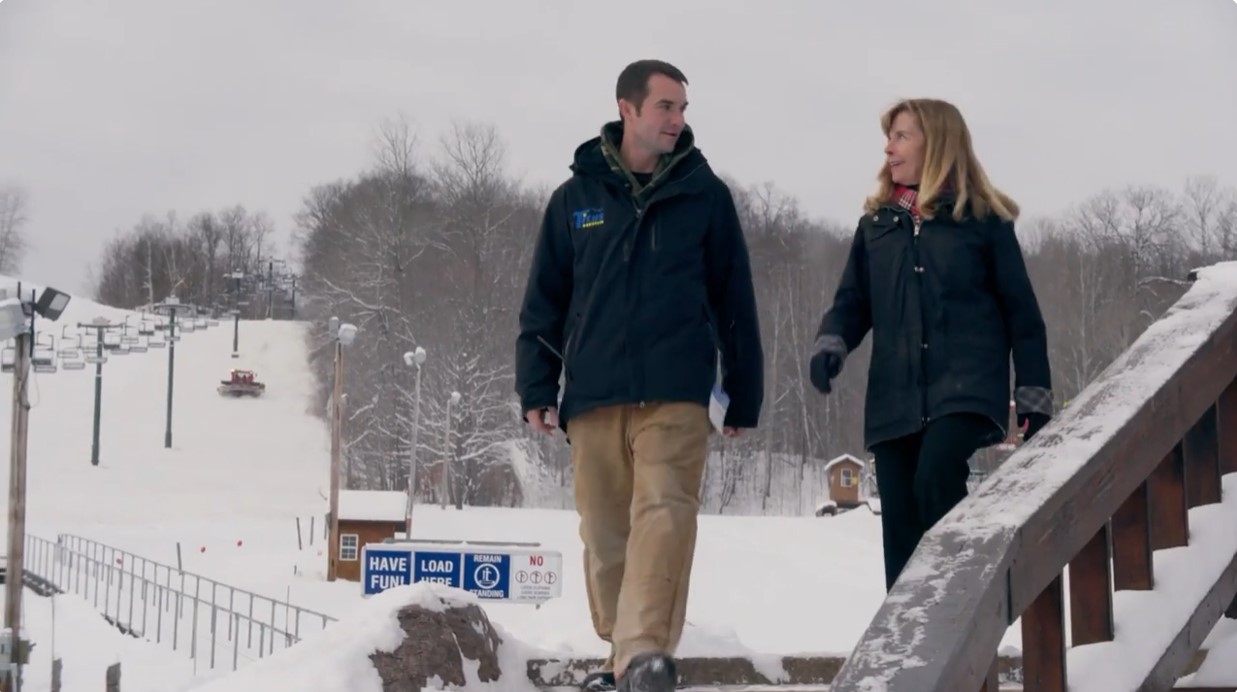 Man and woman walking in snow at ski center
