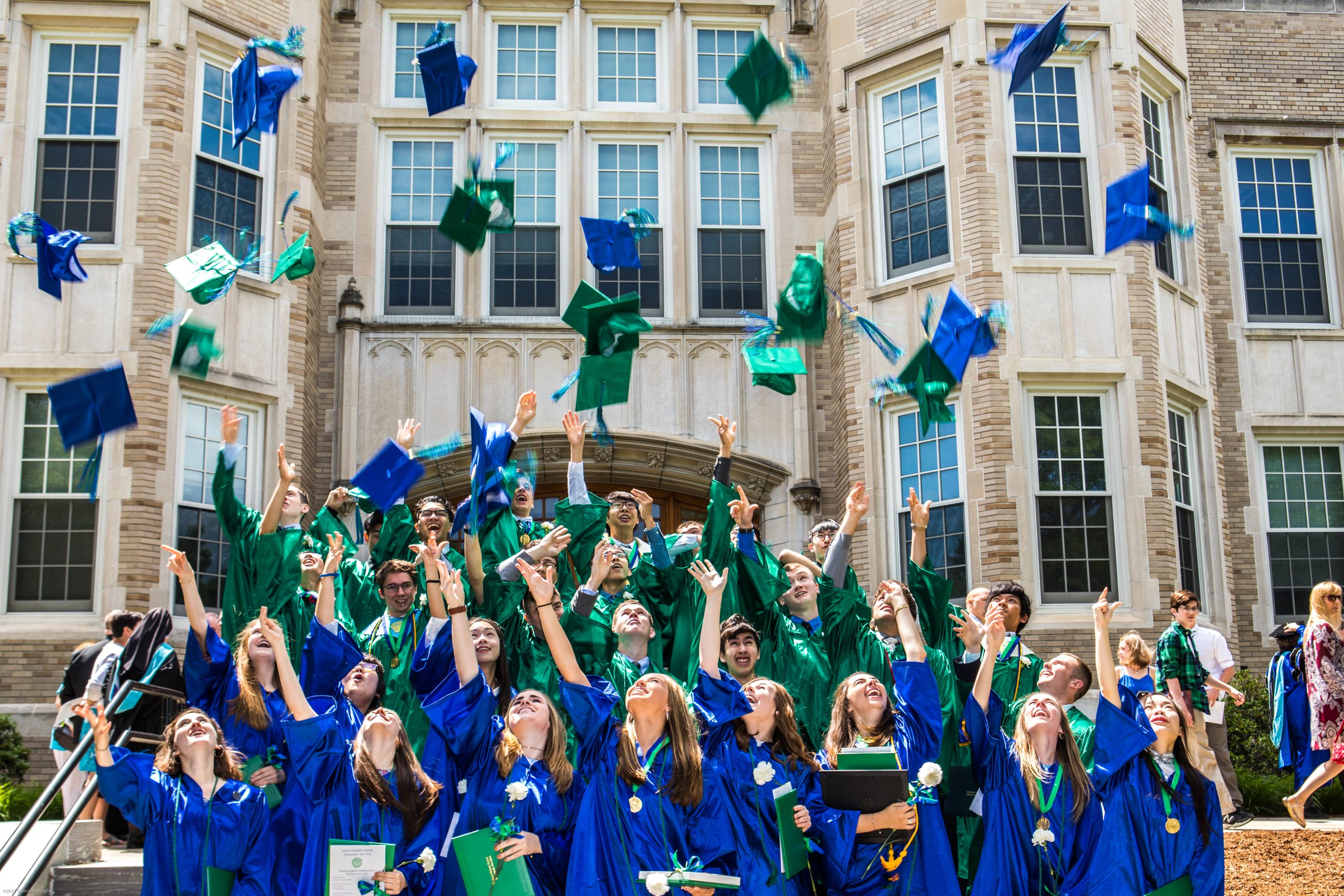 college graduates throwing their caps in the air